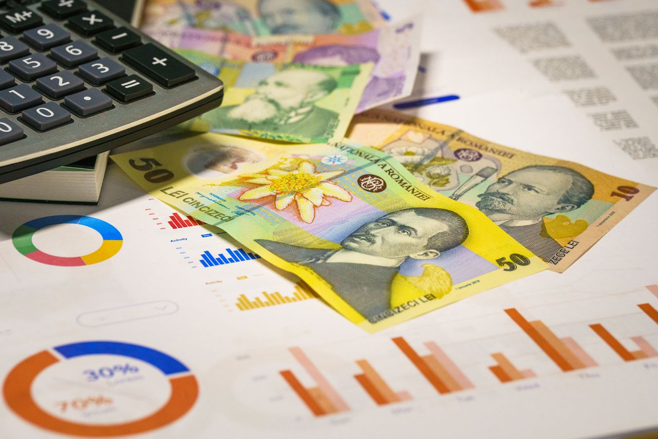 Crafting Captivating Headlines: Your awesome post title goes here Romanian banknotes with graphs and calculator illustrating finance concepts.